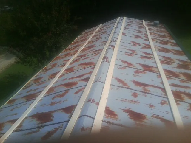 Rusted metal roof panels with new wood purlins before replacement — Storm Damage Roof Repair in Glenolden by Roofing Brothers