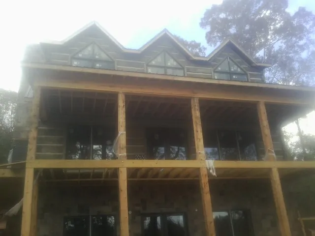 Dormers and porch framing on a large log home under construction — Roof Coating work by our crew in Glenolden