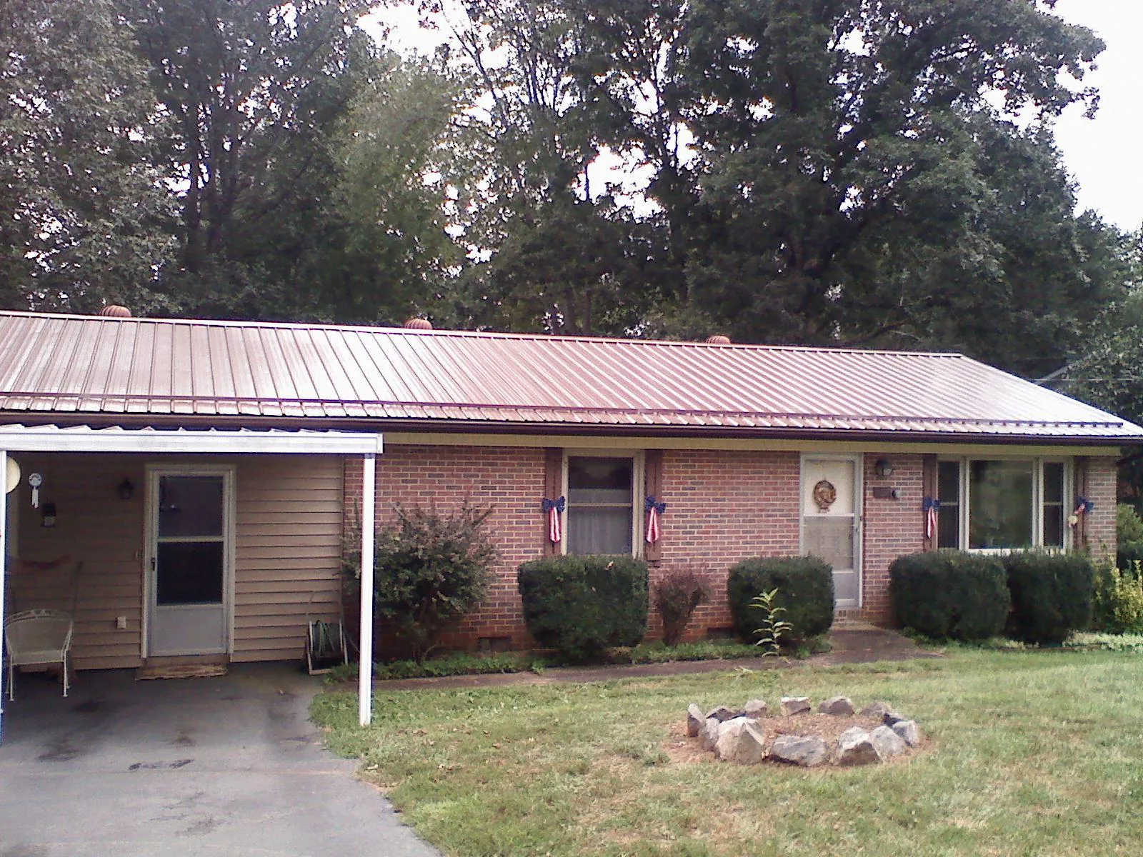 Bronze metal roof and carport on a brick ranch home — Roof Repair work by our crew in Glenolden